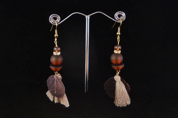 Boucles d_oreilles pendantes brunes sur fond brun